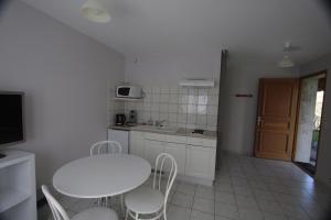 a kitchen with a white table and chairs and a table and a table at Lac et Montagne in Faverges