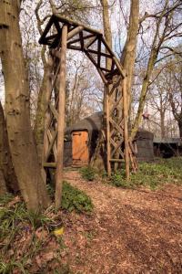 a wooden structure sitting next to a tree at Magical Forest yurt in Sturry