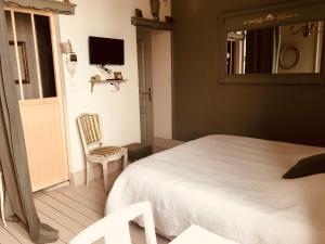a bedroom with a bed and a chair and a mirror at A La Dolce Vita in Blériot-Plage