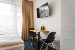 a hotel room with a table and two chairs at Apartments an der Kö in Düsseldorf