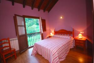 a bedroom with a bed and a large window at Casa de Aldea La Redondiella in Berodia
