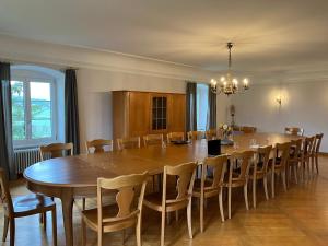 uma grande sala de jantar com uma grande mesa de madeira e cadeiras em Berghof Erlebnis AG em Pfaffnau