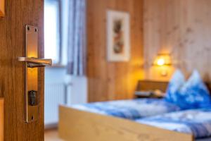 1 dormitorio con 1 cama y puerta de madera en Stöcklhuberhof, en Vandoies