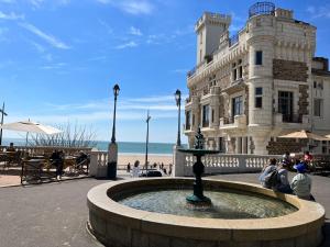 une fontaine en face d'un bâtiment à côté de la plage dans l'établissement L Appart’ Grande Plage, à Les Sables-dʼOlonne