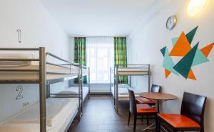 a room with bunk beds and a table and chairs at Jaeger´s Munich (Hotel/Hostel) in Munich