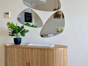 a mirror on a wall above a desk with a plant at Clubrent - Esmeralda Suites 21º piso in Calpe +31 photos