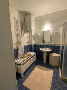 ein blau gefliestes Bad mit einem Waschbecken und einer Badewanne in der Unterkunft Cheerful Bodrum Home in Bodrum City