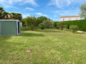a yard with a frisbee in the grass at La Fleur des Marais - Maison tout confort au calme, grand jardin & balançoire in Le Château-dʼOléron