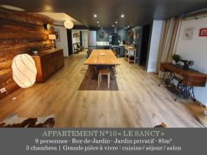 a large room with a wooden table in the middle at La Maison des Familles 10 appartements in Le Mont-Dore