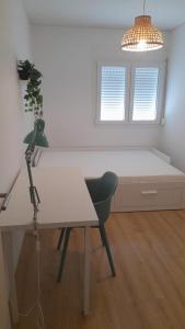 Habitación con escritorio blanco con silla y lámpara. en Carcavelos Beach walking distance room in shared apartment en Oeiras