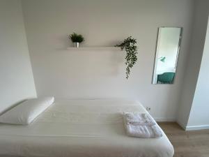 um quarto branco com uma cama branca e um espelho em Carcavelos Beach walking distance room in shared apartment em Oeiras