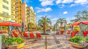 patio z leżakami i parasolami oraz basenem w obiekcie The Marina at Grande Resorts 4-1202-2 bedroom and 2 bath w mieście Myrtle Beach