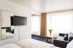 Cette chambre comprend un lit et une télévision. dans l'établissement Apartments an der Kö, à Düsseldorf