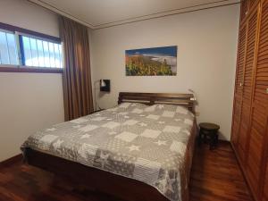 ein Schlafzimmer mit einem Bett mit einer Steppdecke darauf in der Unterkunft Elegant and Peaceful Aparments with Pool and Garden in Puerto de la Cruz