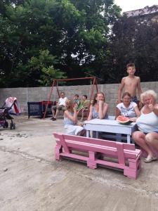 Un groupe de personnes assises autour d'une table de pique-nique dans l'établissement Natalia, à Kobuleti