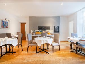 a dining room with white tables and chairs at The Washington in Bristol