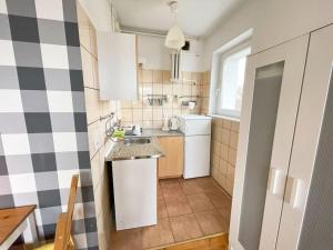 uma pequena cozinha com armários brancos e um lavatório em Cozy studio apartment Yellow in Gdansk Wrzeszcz em Gdansk