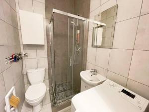 uma casa de banho com um chuveiro, um WC e um lavatório. em Cozy studio apartment Yellow in Gdansk Wrzeszcz em Gdansk