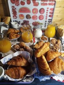 a table with a bunch of pastries and orange juice at O Douceurs Sucrées Cabourg in Cabourg