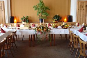 Una mesa larga con un pastel y flores. en Penzion Polnička, en Polnička