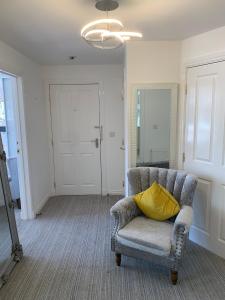 a yellow pillow sitting on a chair in a room at Kensington Luxury Apartment on Gated Development in Leafy edge of Chorley Town Centre in Chorley
