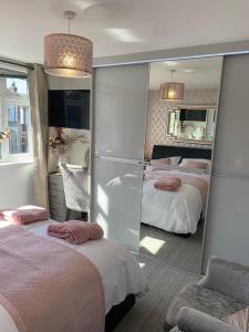 a hotel room with two beds and a mirror at Kensington Luxury Apartment on Gated Development in Leafy edge of Chorley Town Centre in Chorley