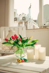 un vase de fleurs et de bougies sur une table dans l'établissement Meraviglie del Sud, à Castellana Grotte