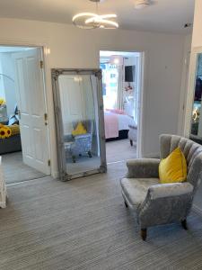 a room with a mirror and a chair and a bed at Kensington Luxury Apartment on Gated Development in Leafy edge of Chorley Town Centre in Chorley