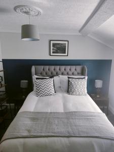 a bedroom with a large white bed with pillows at The Dial inn in Lamphey