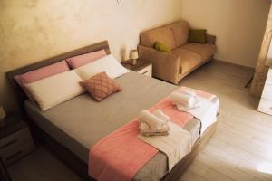 - une chambre avec un grand lit et un canapé dans l'établissement Meraviglie del Sud, à Castellana Grotte