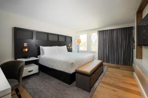 um quarto de hotel com uma cama grande e uma cadeira em Hotel Hartness em Greenville