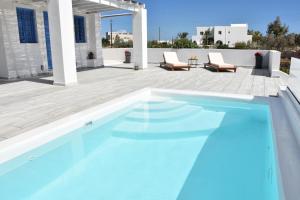 a swimming pool with blue water on a patio at Spacious veranda, house for 3, in the village. in Kamari