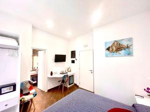 Habitación blanca con cama y escritorio. en Dimora Poseidon, en Tropea