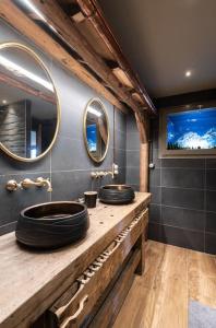 two sinks in a bathroom with two mirrors at Luxueux chalet avec vue sur les pistes et le Hohneck in Le Tholy