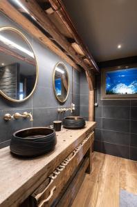 dwie umywalki w łazience z dwoma lustrami w obiekcie Luxueux chalet avec vue sur les pistes et le Hohneck w mieście Le Tholy