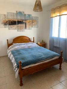 - une chambre avec un lit en bois et une couverture bleue dans l'établissement Villa sud de la France avec piscine privée, à Les Fumades-Les Bains