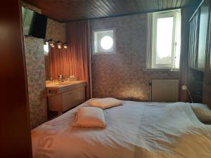 Dormitorio pequeño con cama y lavamanos en On our way to Antwerp, first stop, en Mortsel