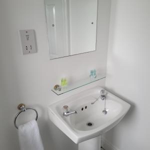 bagno con lavandino bianco e specchio di Dun Maeve Guesthouse a Westport