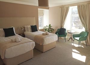 a hotel room with two beds and a table and chairs at Abbeyfield B&B in Dufftown