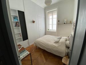 a small bedroom with a bed and a window at Beautiful 3BR Apt in Lyon Center in Lyon
