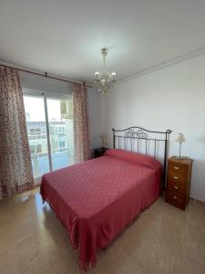 1 dormitorio con cama roja y ventana grande en Alpen 1 La Volta II, en Peñíscola