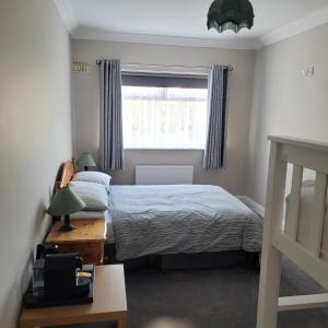 a bedroom with a bed and a window and a desk at Dun Maeve Guesthouse in Westport