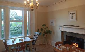 a dining room with a table and a fireplace at Abbeyfield B&B in Dufftown