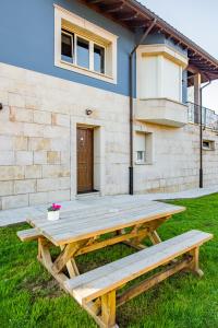 a wooden picnic table in front of a house at Apartamento Cangas Relax in Cangas de Onís