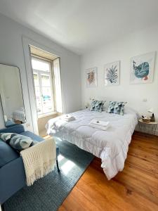 a bedroom with a large bed and a blue couch at Centro da Vila in Ponte de Lima