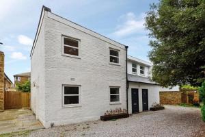 a white brick house with a driveway at Amazing 3 Bed Interior Designed House with Garden - 114 The Hervey in London