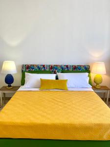 a bedroom with a large yellow bed with two lamps at Casa Graziusa in Palermo