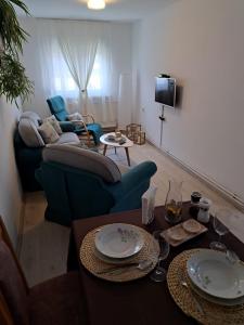 een woonkamer met een bank en een tafel bij Apartman BLOOM in Petrovaradin