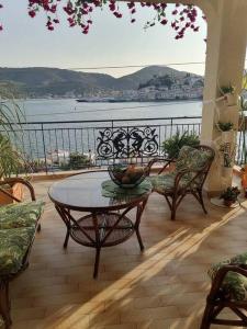 een patio met een tafel en stoelen en uitzicht op het water bij SuiteViewPoros in Galatas