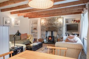 a living room with a stone fireplace and a table at The Dell of Abernethy - A Woodland hideaway in Nethy Bridge